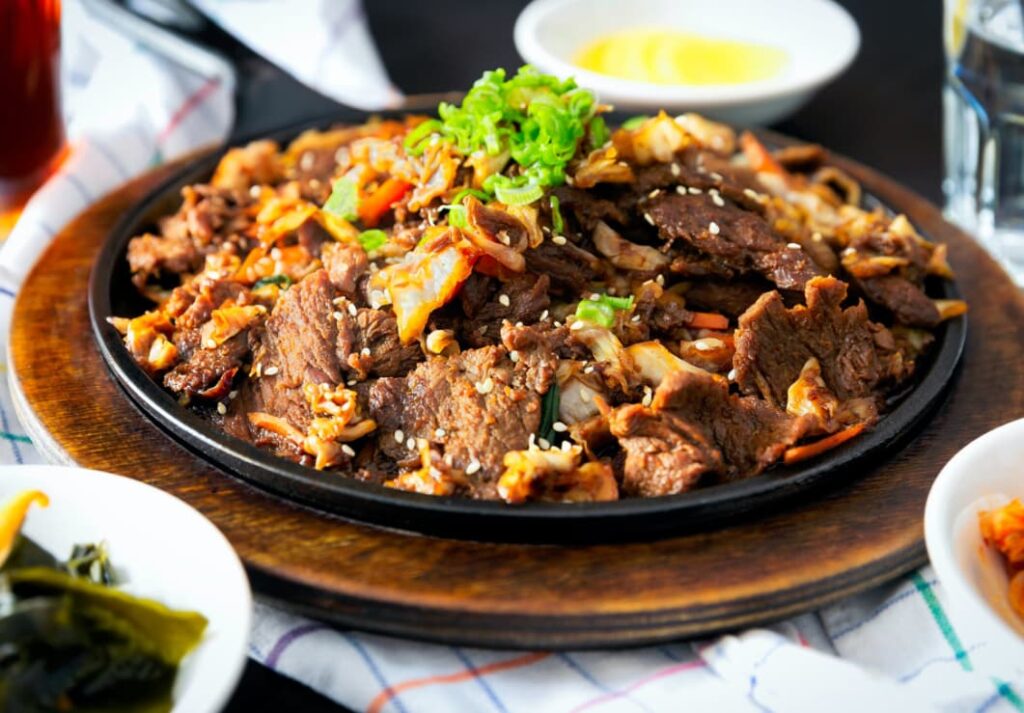 Sizzling Korean bulgogi beef with vegetables and kimchi