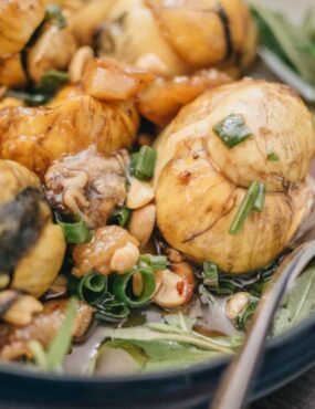A traditional Asian dish with balloon-like mushrooms, nuts, and green onions in a bowl