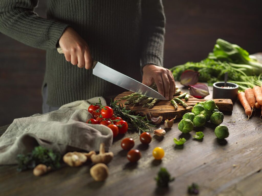 a man cuts vegetables on the table with a knife