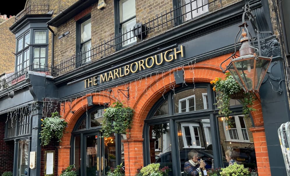 The exterior of 'The Marlborough' pub with ornate brickwork and hanging plants