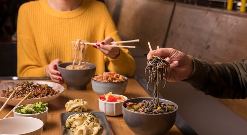 Couple Enjoying Dishes in Asian Restaurant