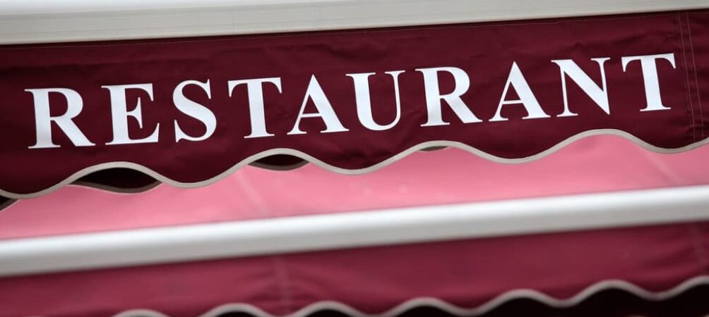 A maroon restaurant awning with the word "RESTAURANT" in white