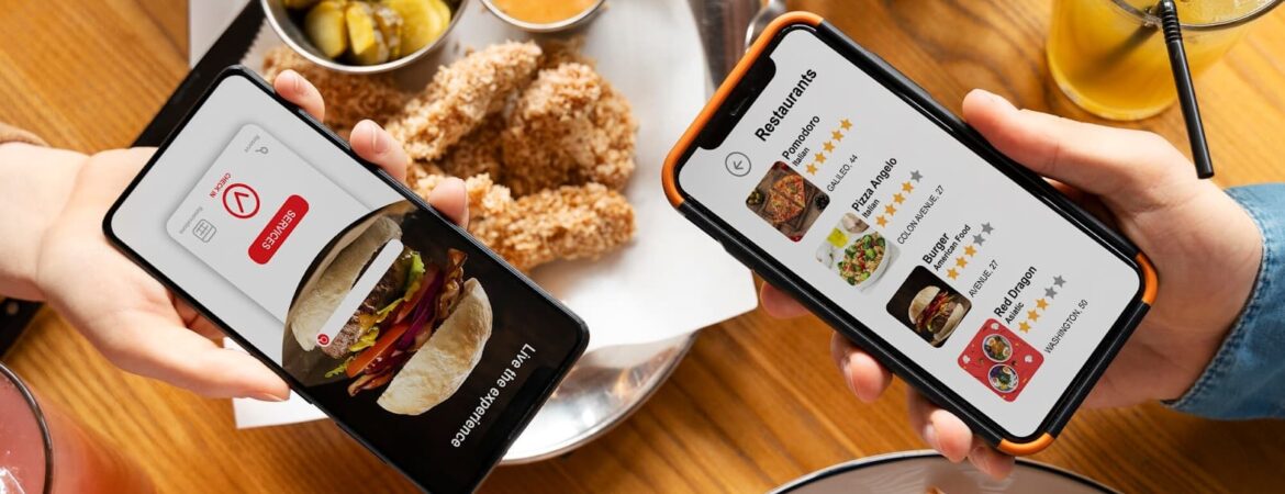 Hands holding smartphones with delivery apps on the background of food