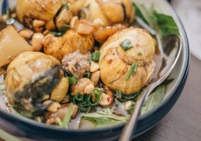 A traditional Asian dish with balloon-like mushrooms, nuts, and green onions in a bowl