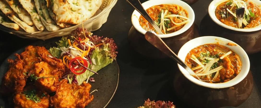 Indian food spread with naan, pakoras, salad, and curry