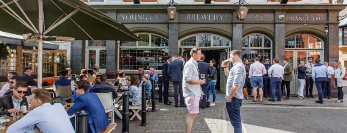 People socializing outside 'The Orange Tree' pub on a sunny day
