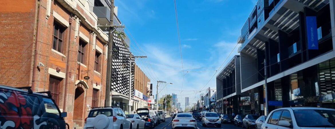 A sunny day on a busy city street with modern and historical buildings