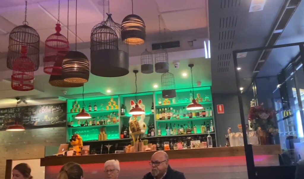 Interior of a restaurant with eclectic lighting and a lively bar scene