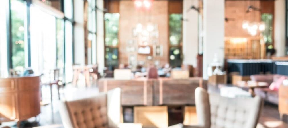A blurred image of a spacious, well-lit restaurant interior with modern decor