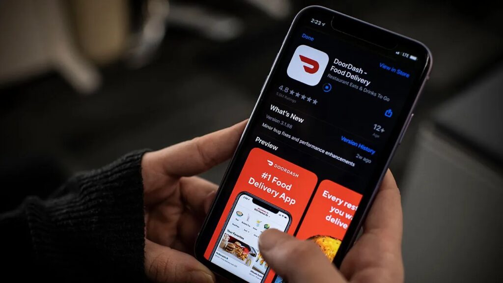Hand holding smartphone with DoorDash app